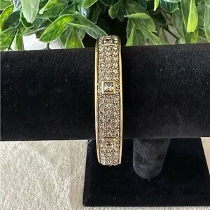 Heidi Daus Hinged Bracelet in Brushed Bronze With Crystals on One Side.